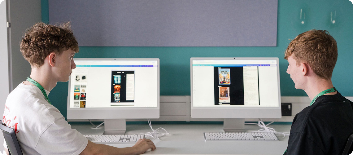 Students sitting in front of Macs computer looking at artworks on the screen
