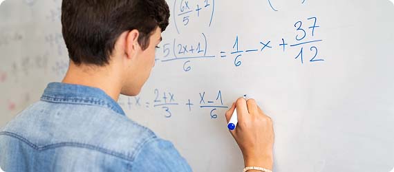Student stood up writing maths on a whiteboard