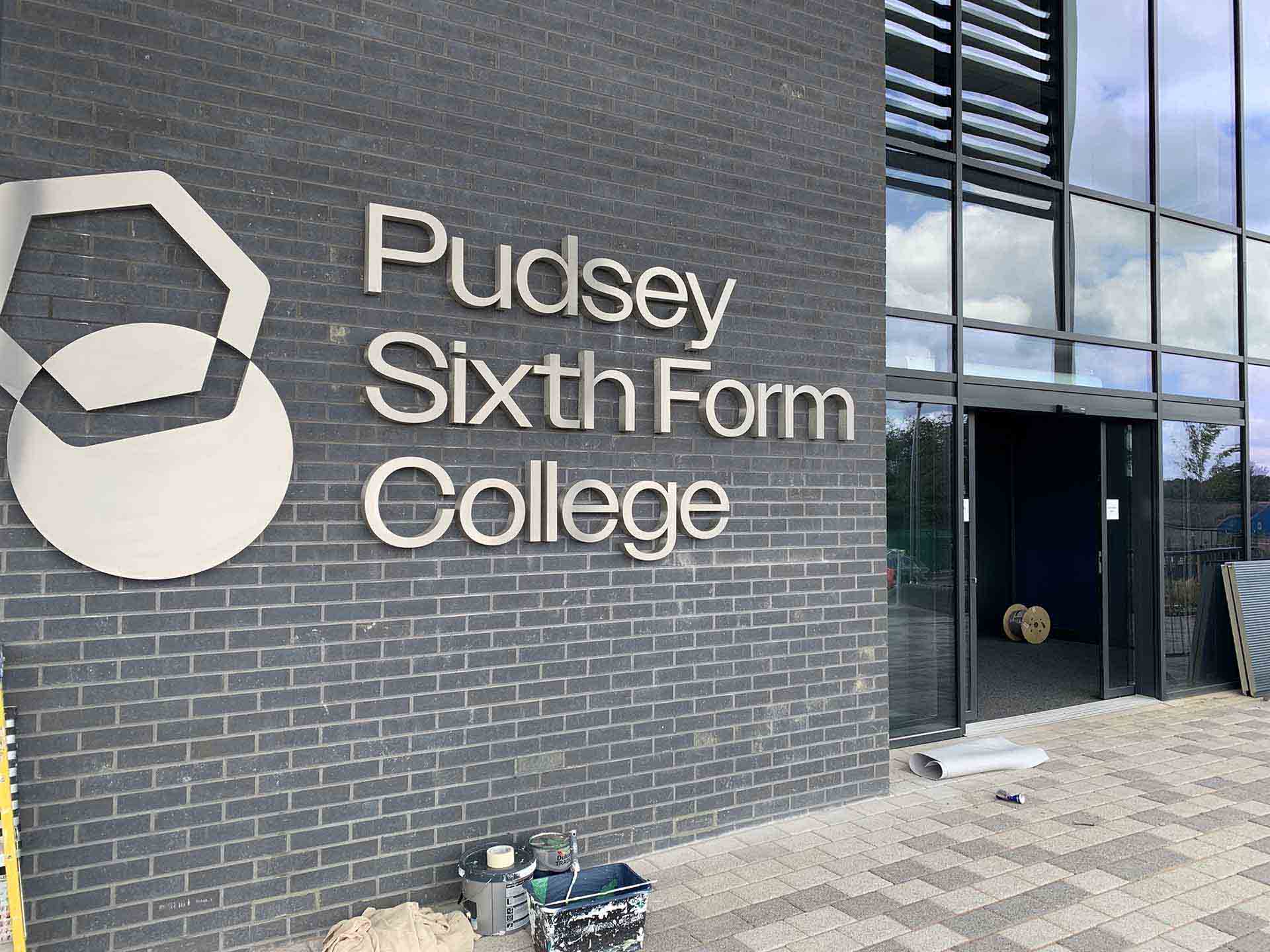 Brick building with sign reads Pudsey Sixth Form College and logo