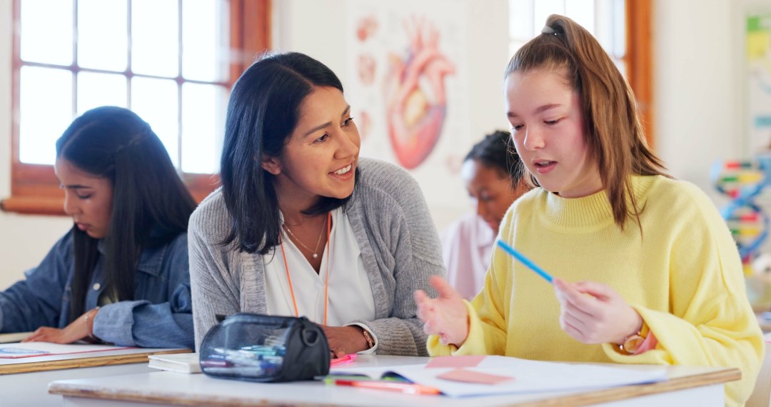 Class of students talk among each other at their desks