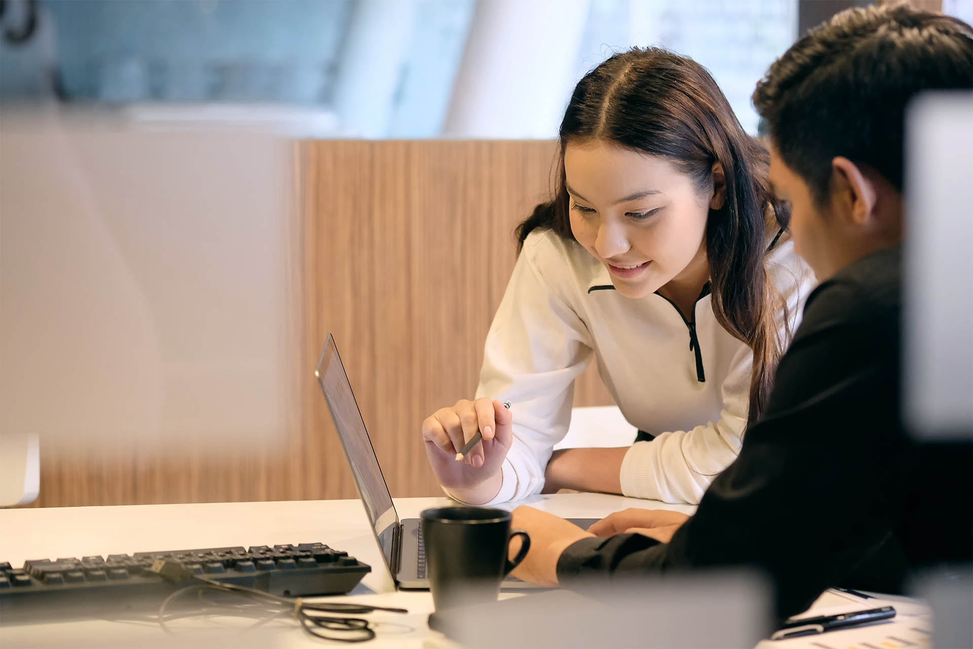 Students talk among each other in front of laptop