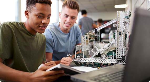 Two students looking at a building project created with meccano