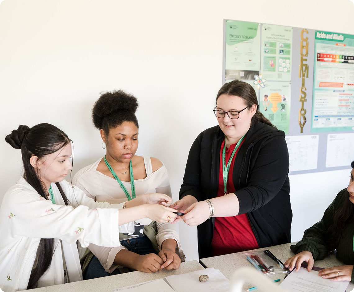 Students working on project in classroom with stationery on the table