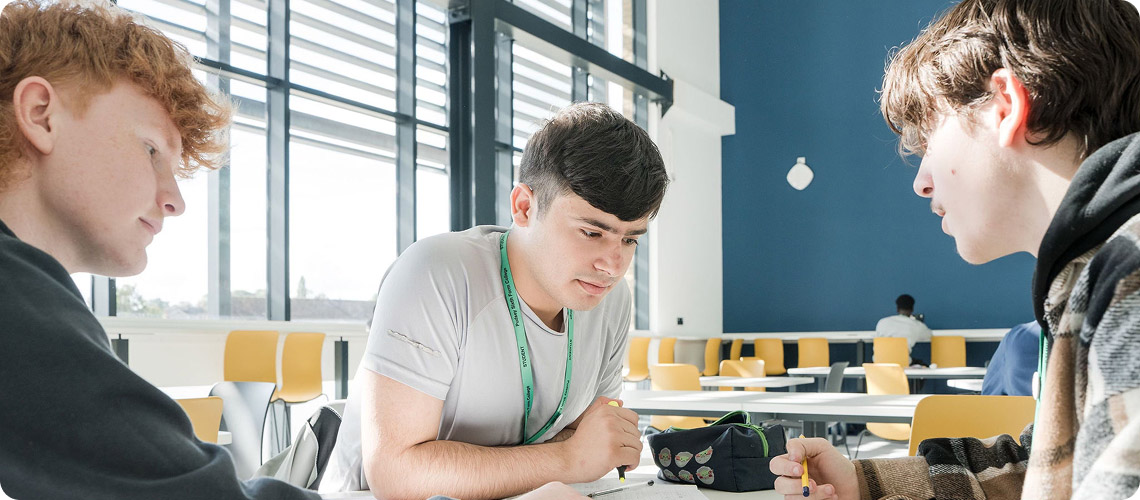 Three students sitting down having discussion together