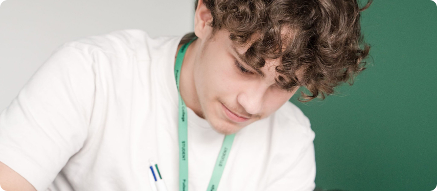 Student wearing white top and green lanyard smiling