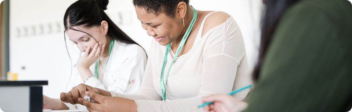 Students sitting in classroom smiling with one student holding a dice