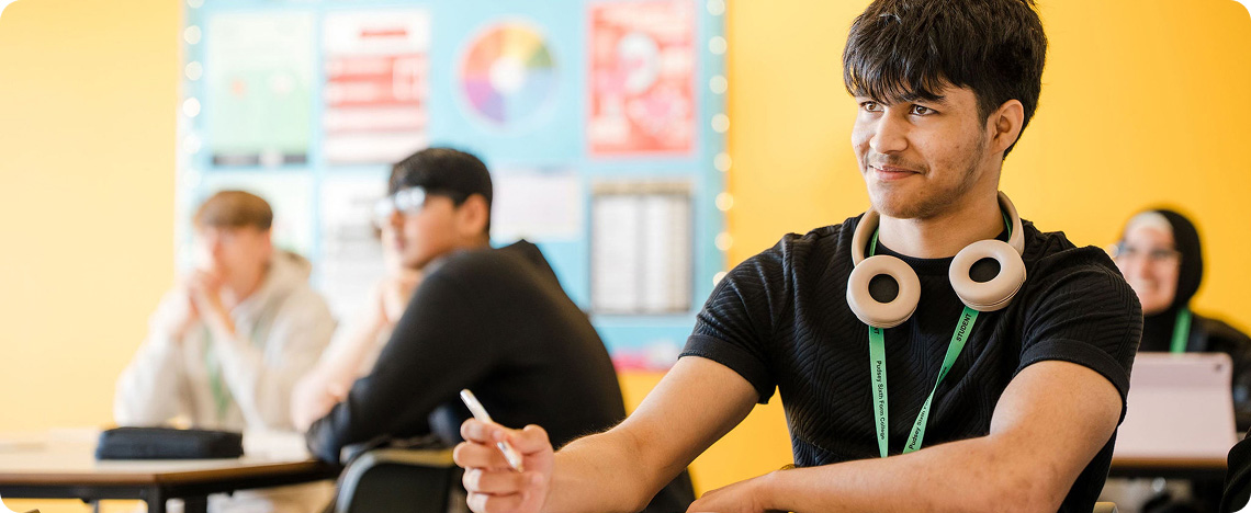 Students in bright yellow wall classroom concentrating on lesson