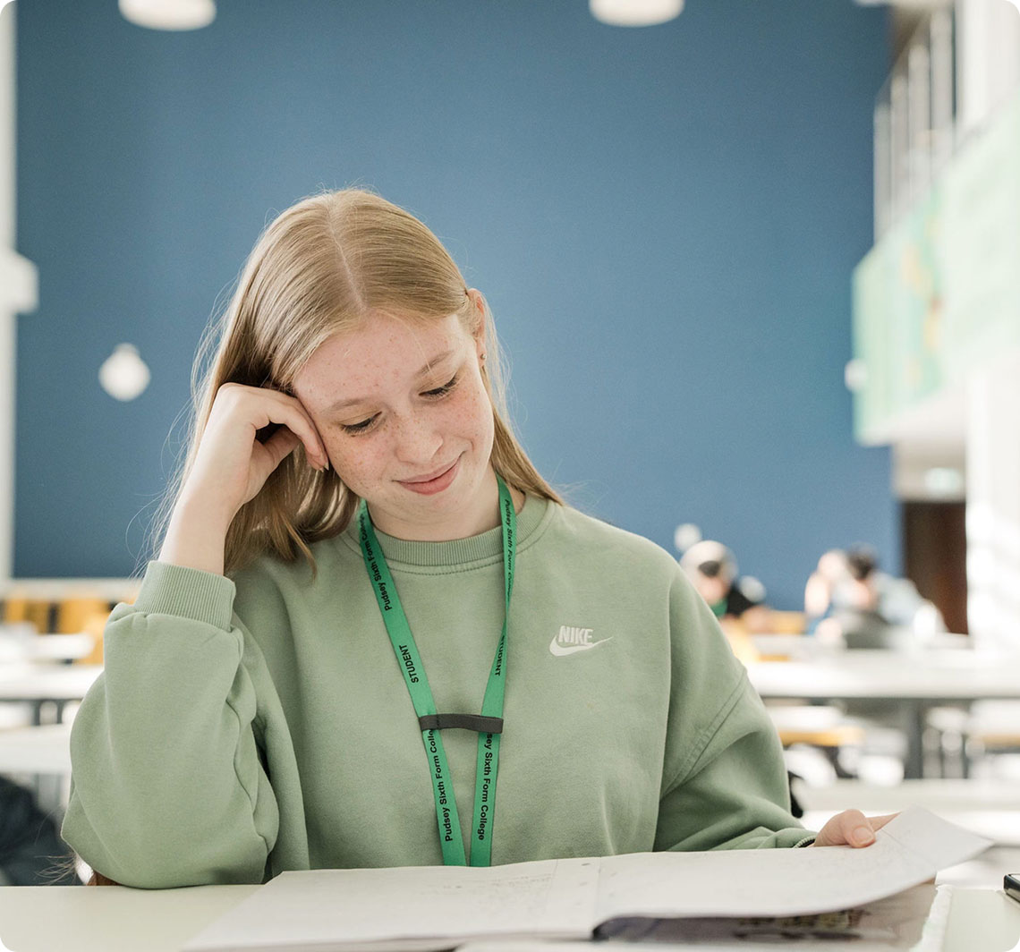 Female student sitting in classroom reading on notes